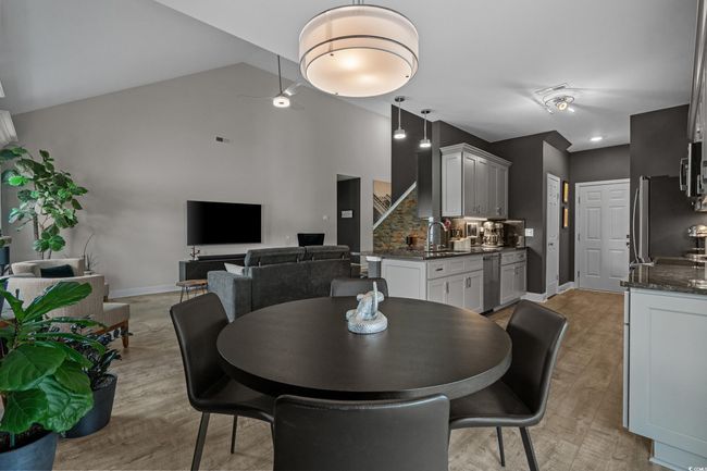 Dining space with light wood-type flooring, high vaulted ceiling, and stairs | Image 12