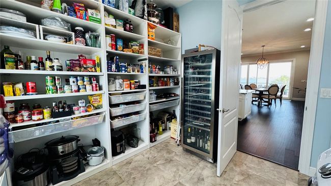 A walk-in pantry/laundry room is conveniently located behind kitchen wall. Plenty of space for a large wine fridge. | Image 38
