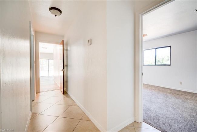 Hall featuring light tile patterned flooring and baseboards | Image 24