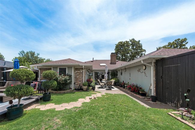Back of property with a chimney, a yard, a patio, and a shingled roof | Image 31