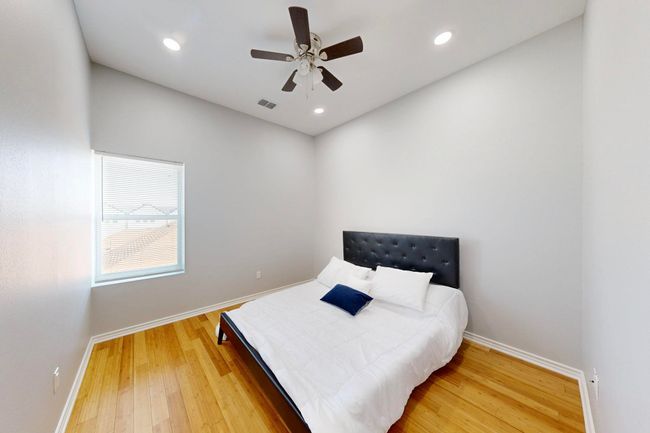 Bedroom with baseboards, light wood finished floors, a ceiling fan, and recessed lighting | Image 16