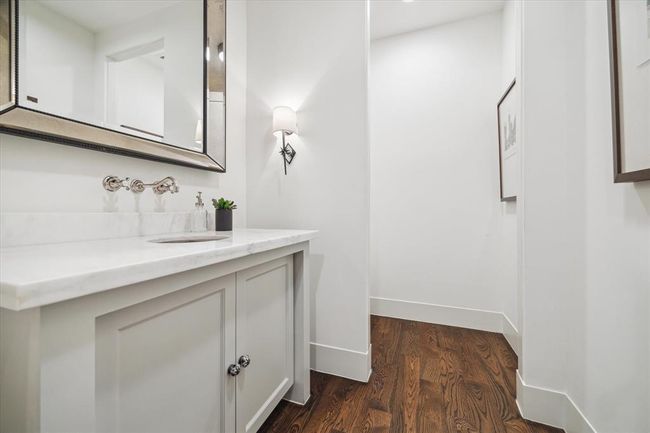 POWDER. Tucked away under the stairs, the entry to the powder features a stunning antique mirrored storage closet. | Image 14