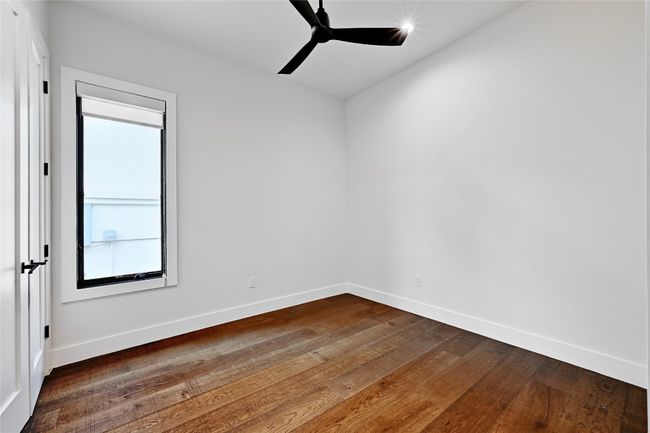 Empty room featuring dark wood-style floors, baseboards, and a ceiling fan | Image 23