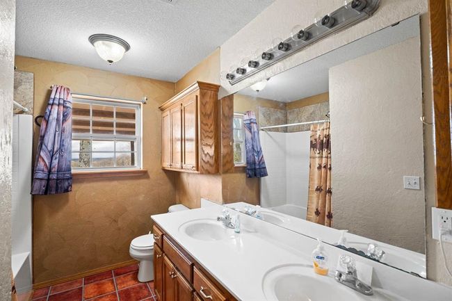 Full bathroom with shower / tub combo, toilet, a sink, and a textured ceiling | Image 30