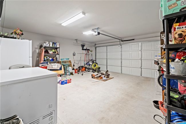 Garage with a garage door opener, fridge, and freestanding refrigerator | Image 30