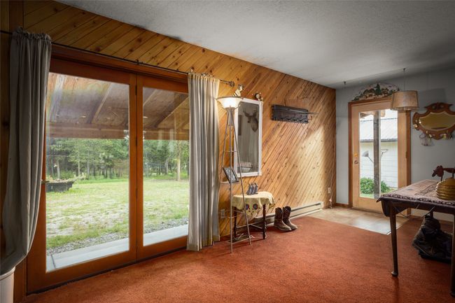 Entryway with wooden walls, light colored carpet, and a textured ceiling | Image 35