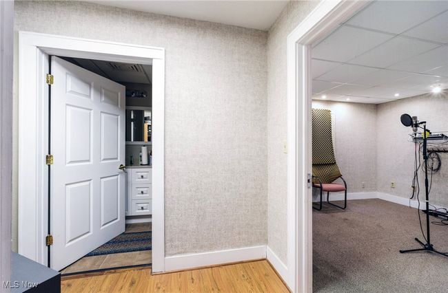 Corridor featuring visible vents, wallpapered walls, light wood-type flooring, and baseboards | Image 11