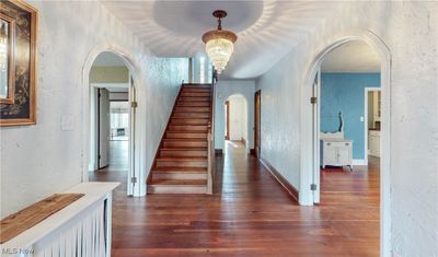 Foyer entrance featuring dark hardwood / wood-style flooring and a notable chandelier | Image 3