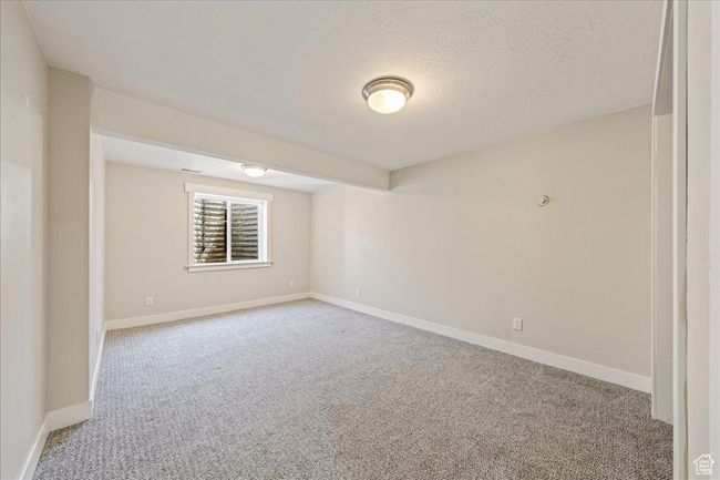 Spare room with a textured ceiling, baseboards, and light carpet | Image 47