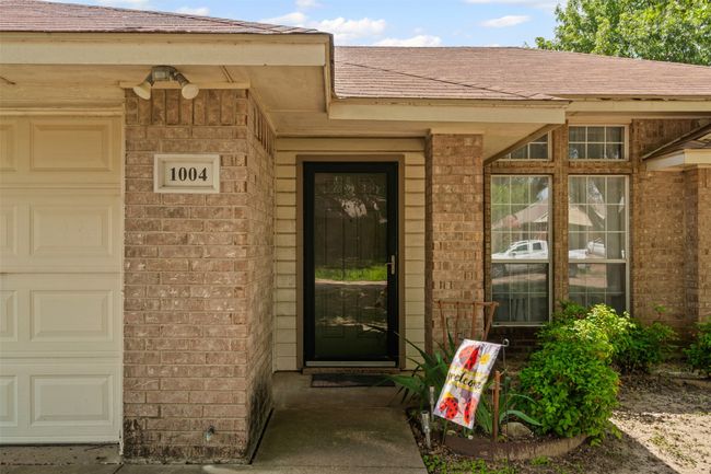 Entrance to property with brick siding, a shingled roof, and a garage | Image 6
