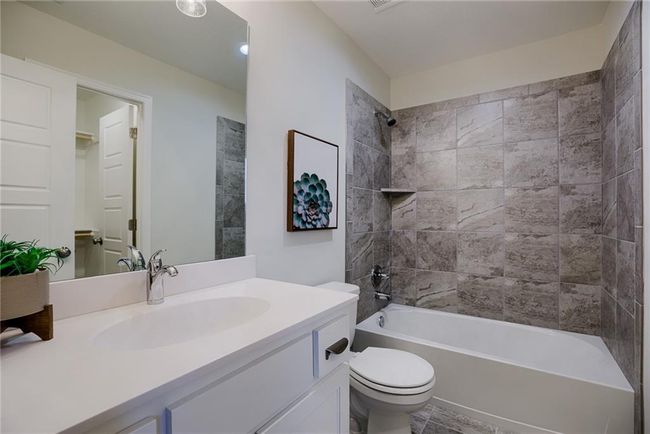 Full bathroom featuring tiled shower / bath, vanity, and toilet | Image 40