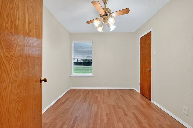 Empty room with light wood-style floors and ceiling fan | Image 14