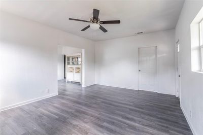 Unfurnished room with dark wood-type flooring and ceiling fan | Image 3