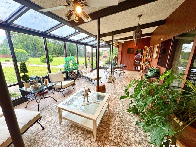 Sunroom with a ceiling fan, an outdoor hangout area, and beamed ceiling | Image 40