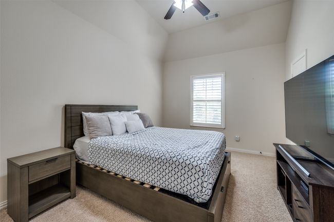 The secondary bedroom on the second floor features plush carpeting, a ceiling fan for year-round comfort, and a spacious walk-in closet." | Image 29