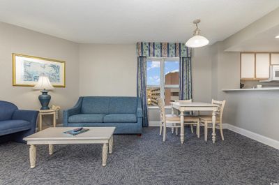 Living room with a textured ceiling and carpet floors | Image 3