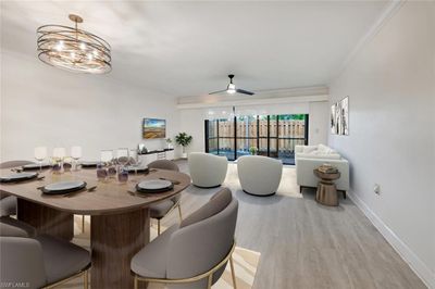 Dining area featuring ceiling fan with notable chandelier, crown molding, and light hardwood / wood-style flooring | Image 1