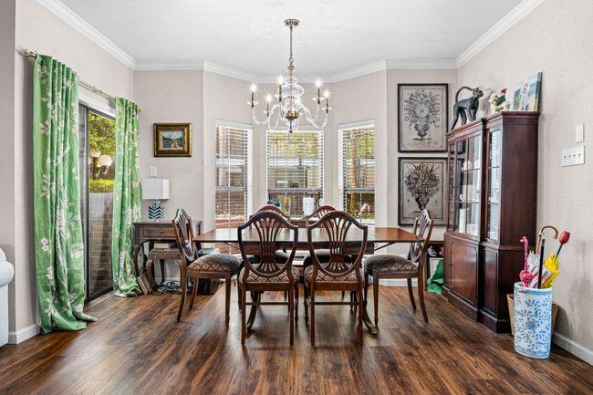 Dining space featuring wood finished floors, a chandelier, and crown molding | Image 10