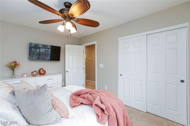 Bedroom with a closet, light colored carpet, and ceiling fan | Image 34