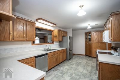 Big kitchen with laminate counter tops, stainless and white appliances, stainless French refrigerator (new in 2020), (dishwasher and disposal new in 2024), honey oak cabinets and double cabinet pantry in the corner. | Image 3