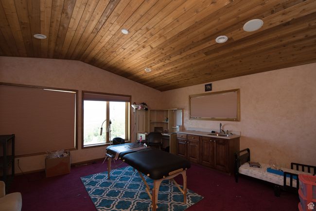 Interior space with vaulted ceiling, carpet flooring, a sink, and wooden ceiling | Image 66