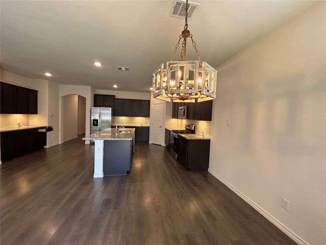 Kitchen with stainless steel appliances, arched walkways, tasteful backsplash, a chandelier, and recessed lighting | Image 28