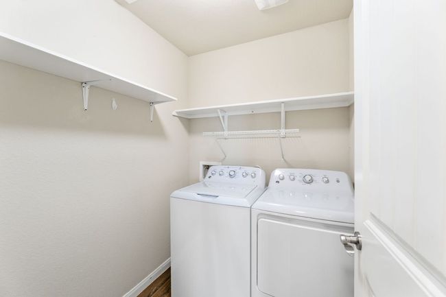 Laundry room with washer and clothes dryer, baseboards, laundry area, and dark wood-style floors | Image 13