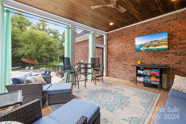 The Screened porch overlooks the in-ground pool and the backyard. | Image 15