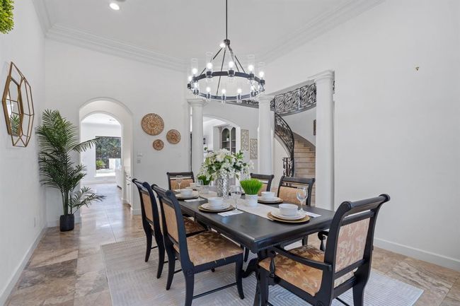 Dedicated dining room with access from the kitchen through the butler’s pantry. A chandelier, columns, and abundant natural light create a warm, inviting atmosphere for hosting family and guests. | Image 15