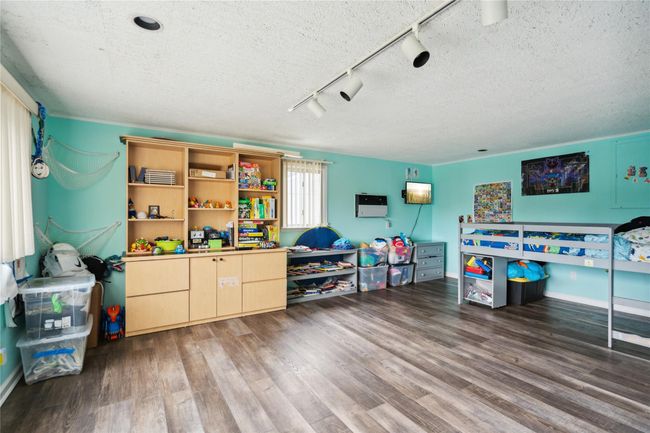 Playroom featuring track lighting, wood finished floors, and a textured ceiling | Image 15