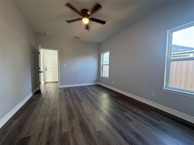 Empty room featuring ceiling fan and dark wood-style flooring | Image 19