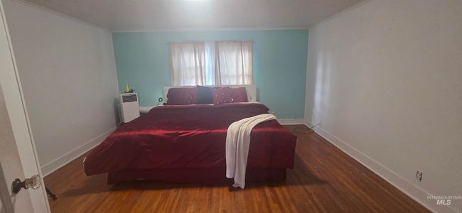 Bedroom with wood finished floors and ornamental molding | Image 19