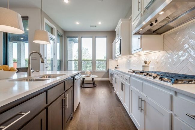 Kitchen featuring exhaust hood, a sink, appliances with stainless steel finishes, dark wood-type flooring, and light countertops | Image 37