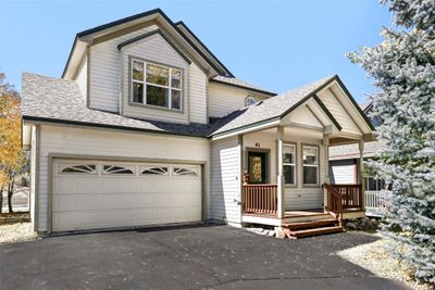 View of front facade with a porch and a garage | Image 1