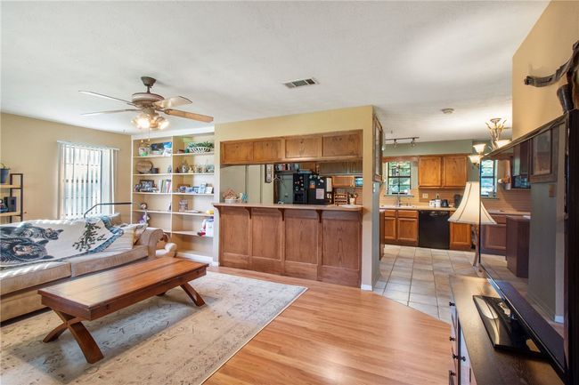 Living area featuring ceiling fan and light wood-style flooring | Image 13