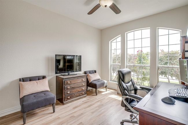 Office space featuring healthy amount of natural light, light wood finished floors, and a ceiling fan | Image 32