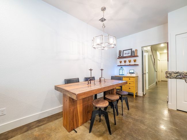 Dining space with finished concrete flooring and a chandelier | Image 8