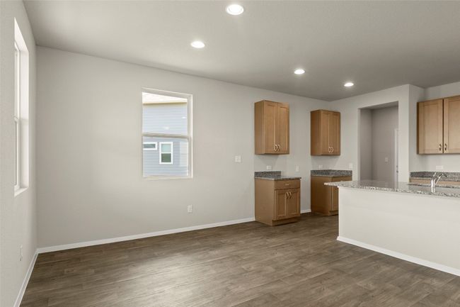 Kitchen with dark wood-style floors, recessed lighting, and light stone counters | Image 14