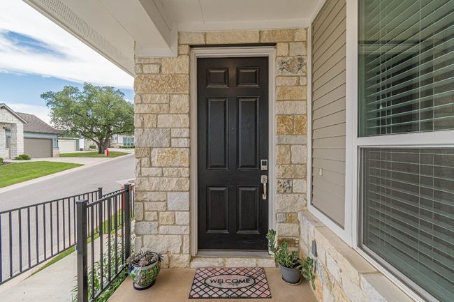 Property entrance with stone siding and a porch | Image 6