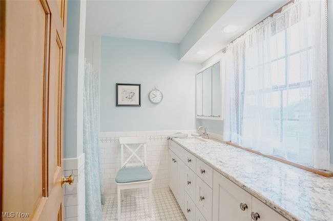Full master bathroom with vanity, tile walls, wainscoting, recessed lighting, and tile patterned floors | Image 21