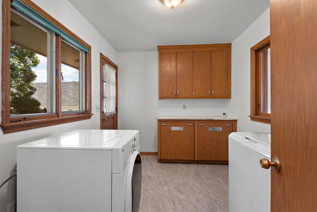 Main floor laundry with utility sink, cabinets, storage pull-out drawers and access to backyard with future potential for deck or patio! | Image 22