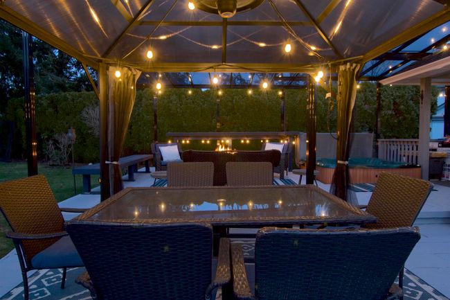 Patio at twilight featuring a gazebo, a hot tub, and outdoor dining area | Image 27