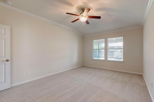 Unfurnished room featuring light carpet, baseboards, crown molding, and ceiling fan | Image 14