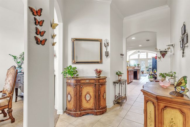 Hallway with arched walkways, crown molding, light tile patterned floors, and recessed lighting | Image 18
