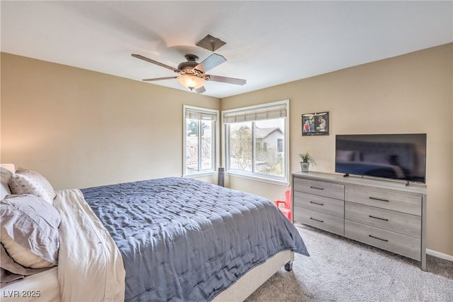 Bedroom featuring ceiling fan, baseboards, and light carpet | Image 25