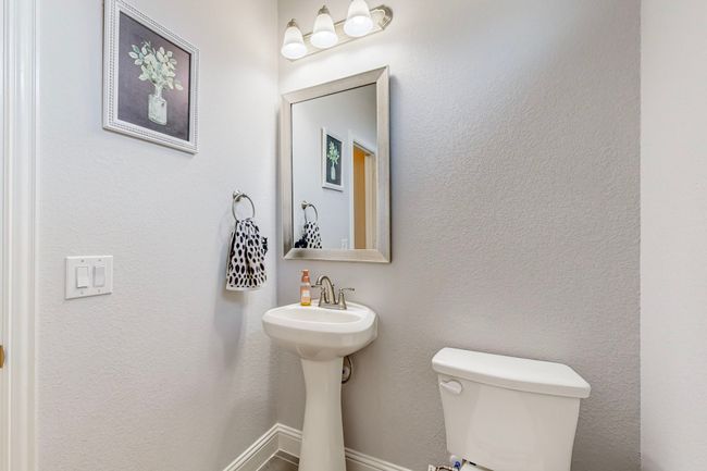 Bathroom with baseboards, toilet, and a textured wall | Image 33