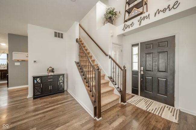 entrance foyer featuring stairs, wood finished floors, baseboards, and healthy amount of natural light | Image 6