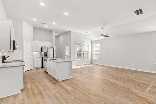 Kitchen with stainless steel appliances, visible vents, a sink, and a ceiling fan | Image 12