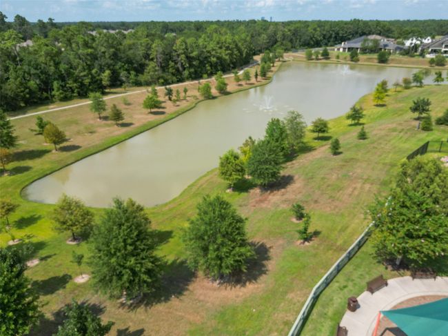Nestled in a peaceful neighborhood, this property features a stunning pond with fountains, surrounded by lush greenery and scenic walking paths, offering a serene, natural retreat. | Image 37