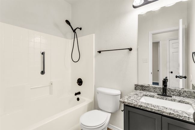Bathroom featuring vanity, shower combination, and a textured wall | Image 14